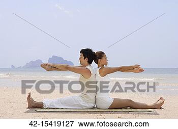 Picture - couple doing yoga 
on beach. fotosearch 
- search stock 
photos, pictures, 
images, and photo 
clipart