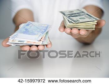 Stock Photo - man holding stacks 
of euros and dollars. 
fotosearch - search 
stock photos, 
pictures, images, 
and photo clipart