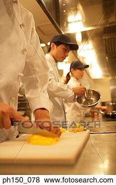 Stock Photo - two male chefs  and a female chef  preparing food  in the kitchen.  fotosearch - search  stock photos,  pictures, images,  and photo clipart