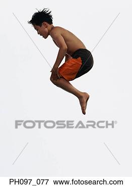 Picture - young asian boy 
in shorts only, 
jumping in mid-air. 
fotosearch - search 
stock photos, 
pictures, images, 
and photo clipart