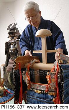 Picture - close-up of a 
person adjusting 
a traditional 
costume on a wooden 
stand. fotosearch 
- search stock 
photos, pictures, 
images, and photo 
clipart