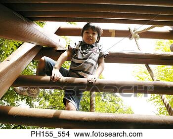 Stock Photo - low angle view 
of a boy playing 
on a jungle gym. 
fotosearch - search 
stock photos, 
pictures, images, 
and photo clipart