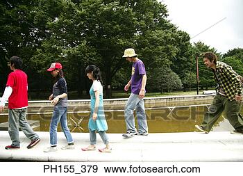 Stock Photograph - side profile of 
three young men 
with two young 
women walking 
along a. fotosearch 
- search stock 
photos, pictures, 
images, and photo 
clipart