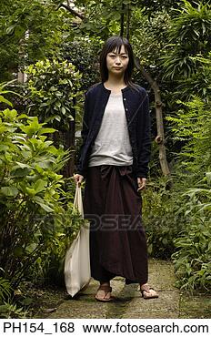 Stock Photo - portrait of a 
young woman standing 
in a garden. fotosearch 
- search stock 
photos, pictures, 
images, and photo 
clipart