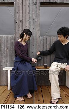 Stock Photo - young couple sitting 
on a bench and 
having tea. fotosearch 
- search stock 
photos, pictures, 
images, and photo 
clipart