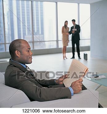 Stock Photo - man sits in an 
armchair reading 
a newspaper,  
two office workers. 
fotosearch - search 
stock photos, 
pictures, images, 
and photo clipart
