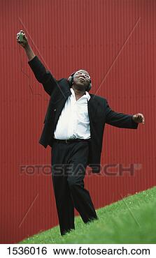 Stock Photo - man in smart clothing 
listening to music 
and dancing with 
his arms. fotosearch 
- search stock 
photos, pictures, 
images, and photo 
clipart