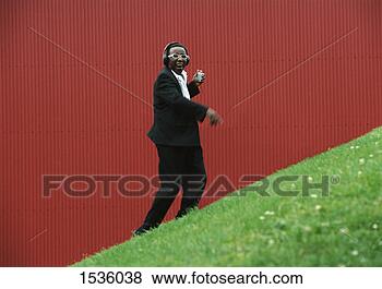 Stock Photo - well-dressed man 
against a red 
background ascending 
a hill listening. 
fotosearch - search 
stock photos, 
pictures, images, 
and photo clipart