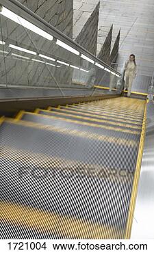 Stock Photo - businesswoman 
stands at the 
bottom of an escalator 
phoning on her. 
fotosearch - search 
stock photos, 
pictures, images, 
and photo clipart