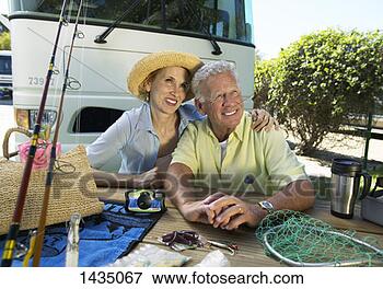 Picture - content senior 
couple sit by 
their motor home, 
 fishing tackle 
on the. fotosearch 
- search stock 
photos, pictures, 
images, and photo 
clipart