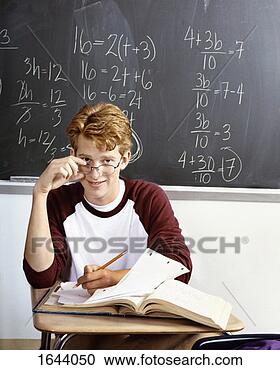 Stock Photography - an intelligent 
looking student 
working at a desk 
in a classroom. 
fotosearch - search 
stock photos, 
pictures, images, 
and photo clipart