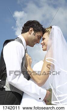 Stock Photography - newlywed couple 
stand face-to-face 
smiling. fotosearch 
- search stock 
photos, pictures, 
images, and photo 
clipart