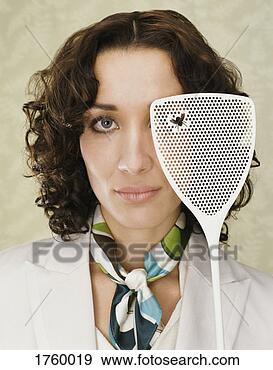 Stock Photograph - portrait of a 
woman holding 
a fly swatter 
with a dead fly 
on it. fotosearch 
- search stock 
photos, pictures, 
images, and photo 
clipart