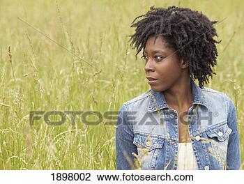 Stock Photo - portrait of a 
woman wearing 
a denim jacket, 
 standing in a 
field and. fotosearch 
- search stock 
photos, pictures, 
images, and photo 
clipart