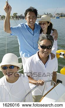 Stock Photo - smiling family 
of four stand 
at the wheel of 
a sailing boat, 
 father. fotosearch 
- search stock 
photos, pictures, 
images, and photo 
clipart