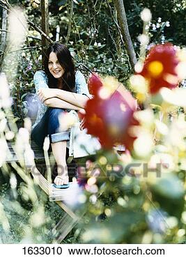 Stock Photography - smiling woman 
sit on a wooden 
bench in a garden 
holding a newspaper. 
fotosearch - search 
stock photos, 
pictures, images, 
and photo clipart