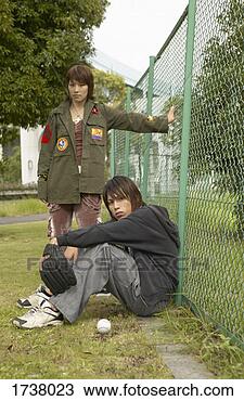 Stock Photo - teenage boy and 
girl with attitude 
sit and stand 
by a wire fence. 
fotosearch - search 
stock photos, 
pictures, images, 
and photo clipart