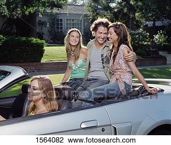 Stock Photo - teenage boy sits 
in the back seat 
of a convertible 
between two girls. 
fotosearch - search 
stock photos, 
pictures, images, 
and photo clipart