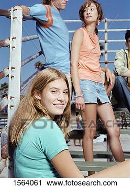 Stock Photography - teenage girl with 
friends sitting 
on benches by 
railings. fotosearch 
- search stock 
photos, pictures, 
images, and photo 
clipart