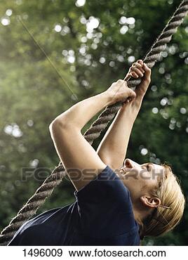 Stock Photograph - woman climbing 
a rope on an assault 
course. fotosearch 
- search stock 
photos, pictures, 
images, and photo 
clipart