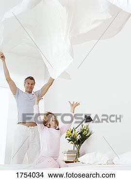 Stock Photo - young girl kneels 
on a bed with 
her arms up,  
her father holding 
a. fotosearch 
- search stock 
photos, pictures, 
images, and photo 
clipart