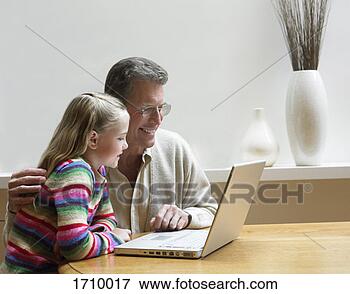 Picture - grandfather and 
his granddaughter 
using a laptop 
pc. fotosearch 
- search stock 
photos, pictures, 
images, and photo 
clipart
