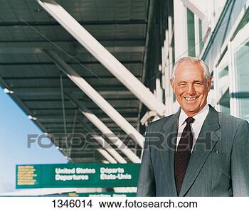 Stock Photo - portrait of a 
businessman standing 
smiling outside 
an airport. fotosearch 
- search stock 
photos, pictures, 
images, and photo 
clipart