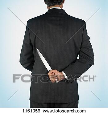 Stock Photo - rear view of a 
busienssman holding 
a dagger. fotosearch 
- search stock 
photos, pictures, 
images, and photo 
clipart