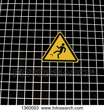 Stock Photo - yellow,  triangular 
warning sign hanging 
from a hook against 
a black. fotosearch 
- search stock 
photos, pictures, 
images, and photo 
clipart