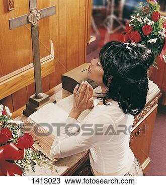 Stock Photo - young woman kneeling 
at an altar in 
church and praying. 
fotosearch - search 
stock photos, 
pictures, images, 
and photo clipart