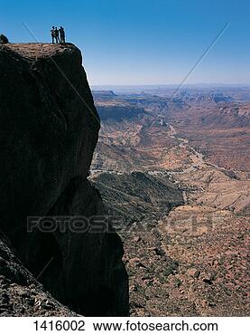 Stock Photo - four people standing 
on top of a cliff 
overlooking the 
southern rift. 
fotosearch - search 
stock photos, 
pictures, images, 
and photo clipart