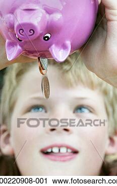 Stock Photography - boy (9-11) tipping 
coins from piggy 
bank, close-up. 
fotosearch - search 
stock photos, 
pictures, images, 
and photo clipart
