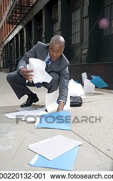 Stock Photography - businessman outdoors, 
picking up spilt 
papers from pavement. 
fotosearch - search 
stock photos, 
pictures, images, 
and photo clipart