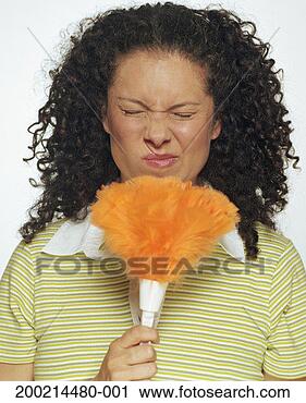Stock Photography - woman holding 
feather duster 
up to face, twitching 
nose, eyes closed. 
fotosearch - search 
stock photos, 
pictures, images, 
and photo clipart