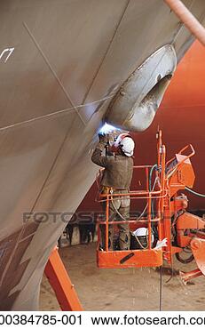 Stock Photography - welder working 
on side of ship 
in dry dock, standing 
on cherry-picker. 
fotosearch - search 
stock photos, 
pictures, images, 
and photo clipart