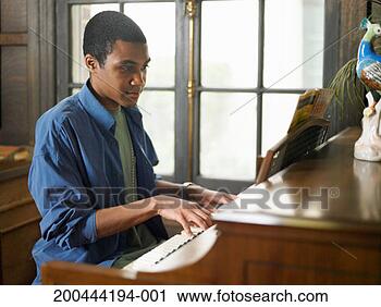 Stock Photography - young man playing 
piano in house. 
fotosearch - search 
stock photos, 
pictures, images, 
and photo clipart
