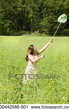 Stock Photography - young woman chasing 
butterflies in 
field. fotosearch 
- search stock 
photos, pictures, 
images, and photo 
clipart