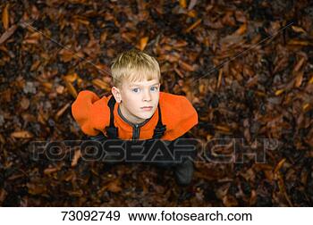 Stock Photograph - boy standing in 
leaves, overhead 
view. fotosearch 
- search stock 
photos, pictures, 
images, and photo 
clipart