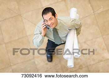 Stock Photo - businessman holding 
drafts, using 
mobile phone, 
elevated view. 
fotosearch - search 
stock photos, 
pictures, images, 
and photo clipart