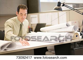 Picture - businessman looking 
at drafts on desk. 
fotosearch - search 
stock photos, 
pictures, images, 
and photo clipart