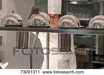 Stock Photography - chef lifting lid 
from food on counter 
in hotel kitchen. 
fotosearch - search 
stock photos, 
pictures, images, 
and photo clipart