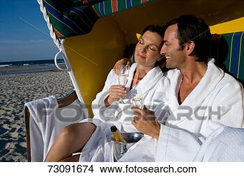 Stock Photo - couple sitting 
in beach shelterdrinking 
champagne. fotosearch 
- search stock 
photos, pictures, 
images, and photo 
clipart