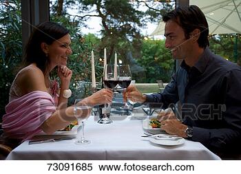 Stock Image - couple toasting 
with red wine 
at restaurant 
table. fotosearch 
- search stock 
photos, pictures, 
images, and photo 
clipart