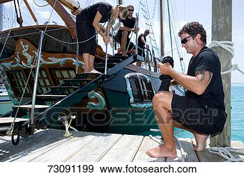 Stock Photograph - crew performing 
various tasks 
on and by sailboat. 
fotosearch - search 
stock photos, 
pictures, images, 
and photo clipart
