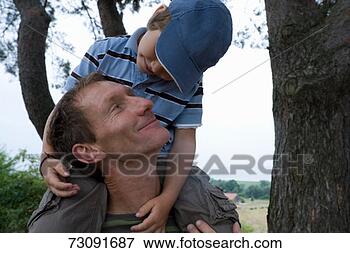 Picture - father carrying 
son (6-7) on shoulderssmilingclose-up. 
fotosearch - search 
stock photos, 
pictures, images, 
and photo clipart