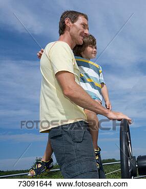 Stock Photo - father driving 
motorboat carrying 
son (6-7) low 
angle view. fotosearch 
- search stock 
photos, pictures, 
images, and photo 
clipart