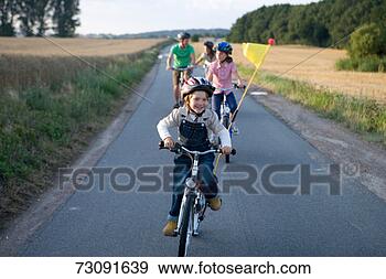 Stock Photograph - father with three 
children (6-11) 
riding bicycles 
on country road. 
fotosearch - search 
stock photos, 
pictures, images, 
and photo clipart
