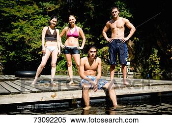 Stock Image - four young people 
in swimwear, on 
wooden dock, portrait. 
fotosearch - search 
stock photos, 
pictures, images, 
and photo clipart