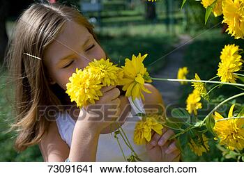 Stock Photography - girl (10-11) smelling 
yellow dahlias 
outdoors. fotosearch 
- search stock 
photos, pictures, 
images, and photo 
clipart