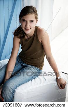 Picture - girl (12-13) sitting 
on couch, smiling. 
fotosearch - search 
stock photos, 
pictures, images, 
and photo clipart